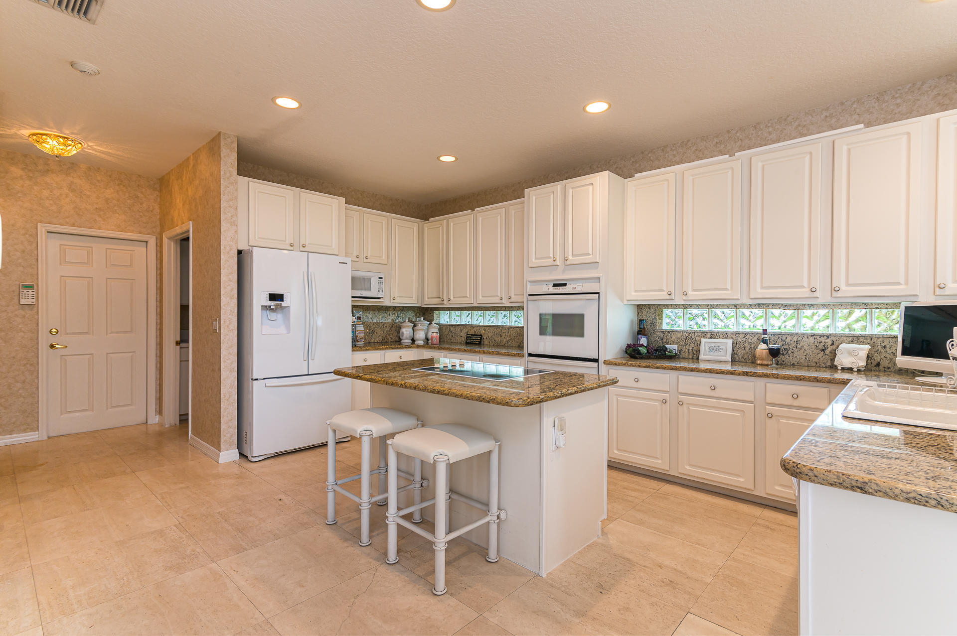 21605 Halstead Drive Boca Raton, FL 33428 - Photo 8 of 43 a kitchen with white cabinets and stainless steel appliances