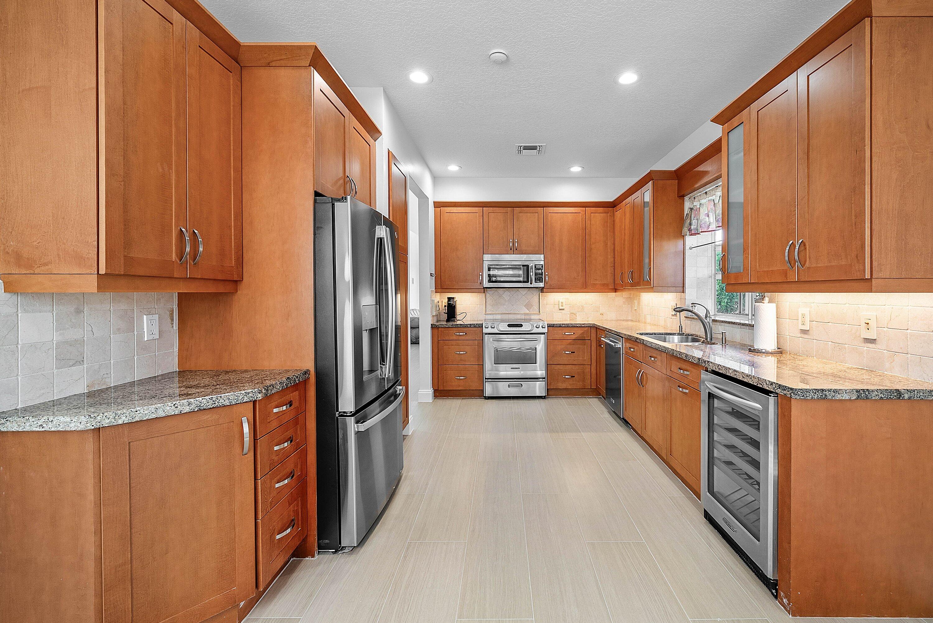 5855 Northwest 42nd Way Boca Raton, FL 33496 - Photo 16 of 77 a kitchen with stainless steel appliances granite countertop a refrigerator and a stove top oven