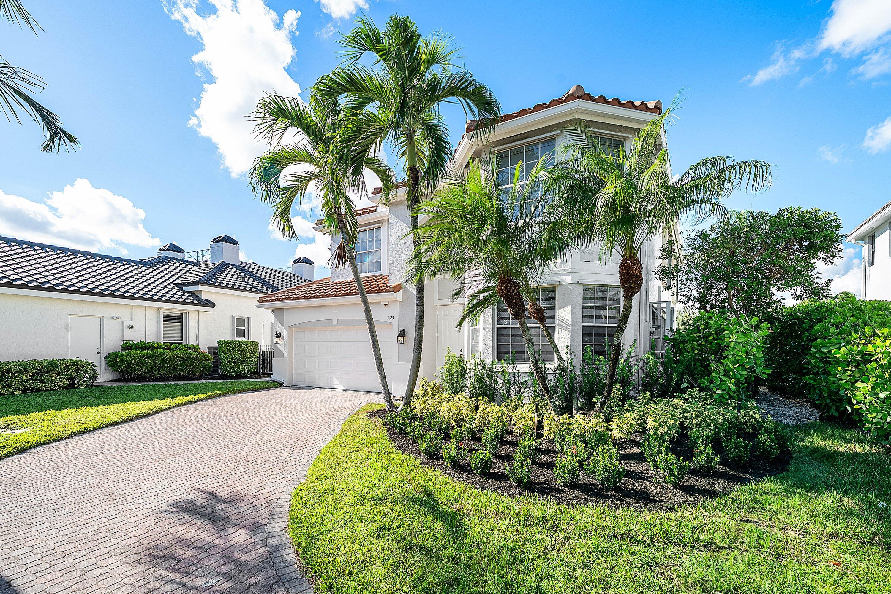 5855 Northwest 42nd Way Boca Raton, FL 33496 - Photo 2 of 77 a front view of a house with a yard and potted plants