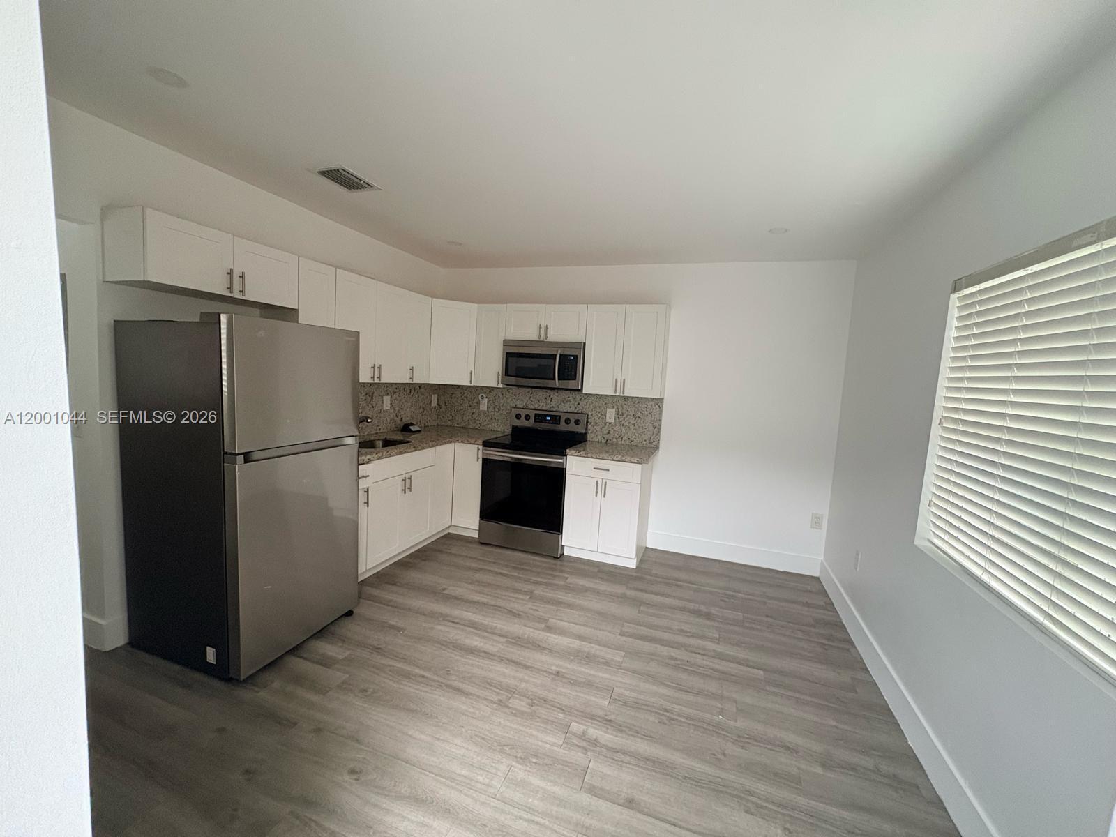 314 Southwest 10th Avenue, Unit 2 Miami, FL 33130 - Photo 6 of 9 a kitchen with granite countertop a refrigerator and a sink