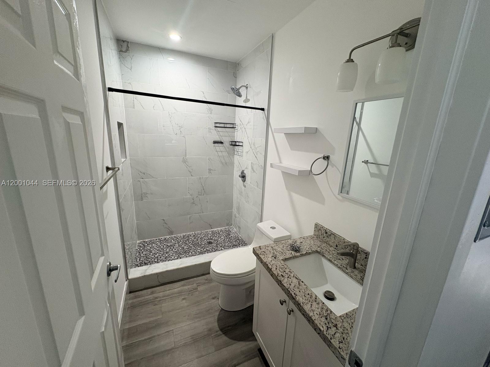 314 Southwest 10th Avenue, Unit 2 Miami, FL 33130 - Photo 9 of 9 a bathroom with a granite countertop sink toilet and shower