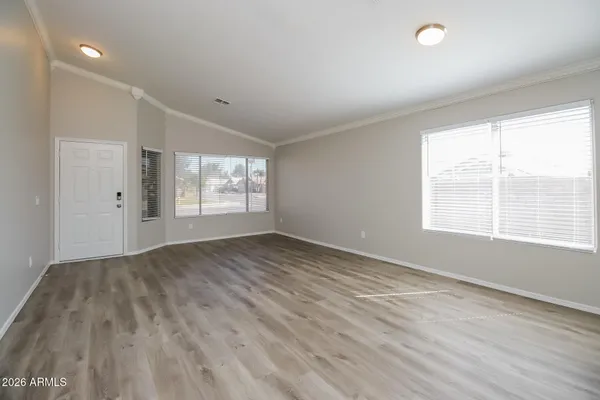 a view of empty room with wooden floor and fan