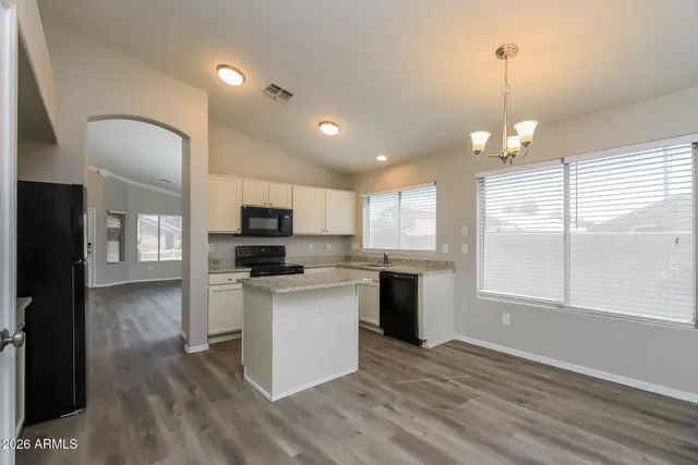 a view of a kitchen with a sink microwave and cabinets