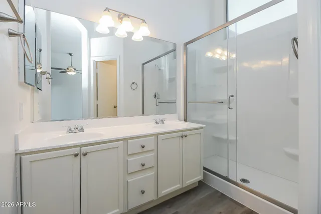 a bathroom with a double vanity sink mirror and shower
