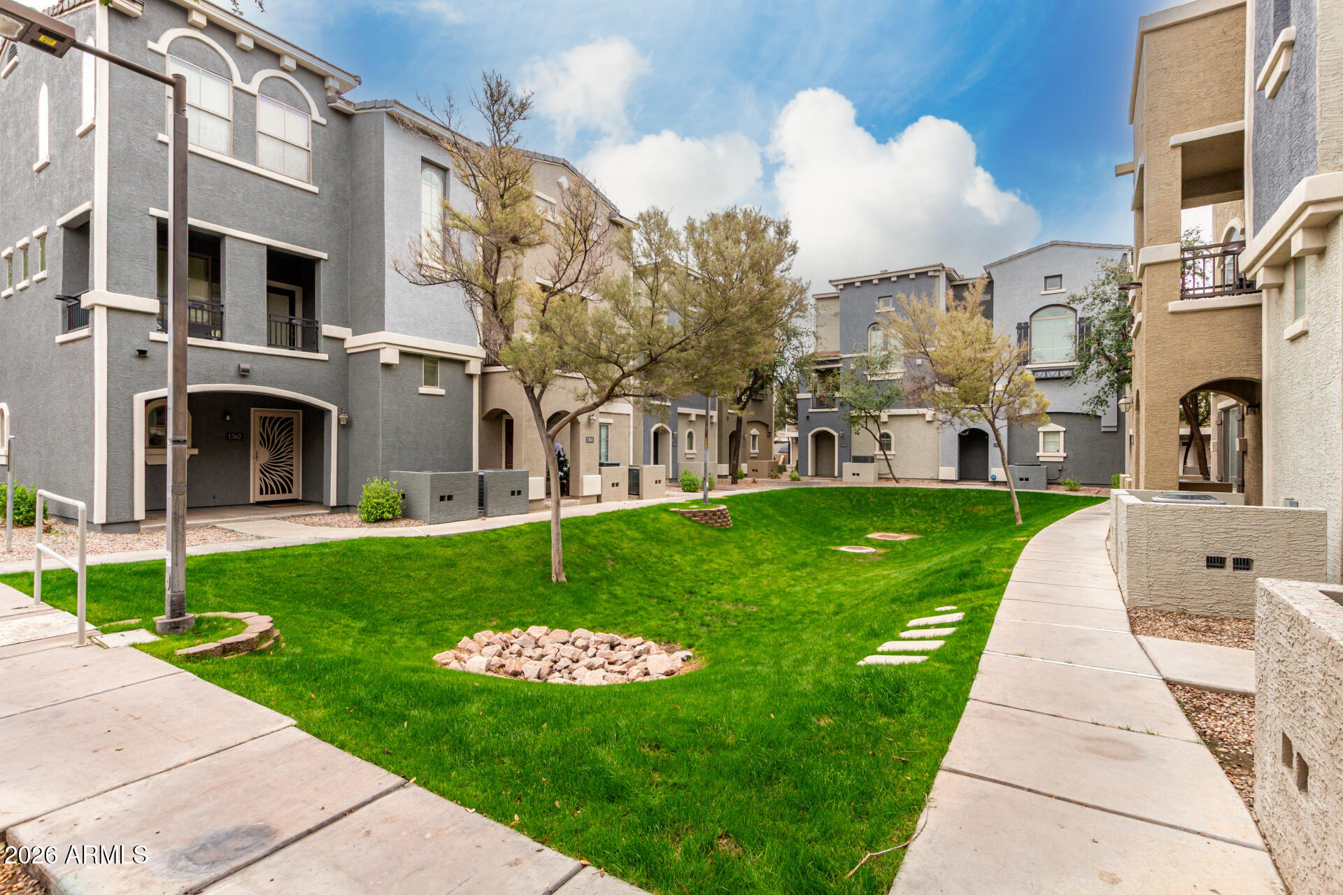 280 South Evergreen Road, Unit 1350 Tempe, AZ 85288 - Photo 39 of 62 a view of a white house with a yard and plants