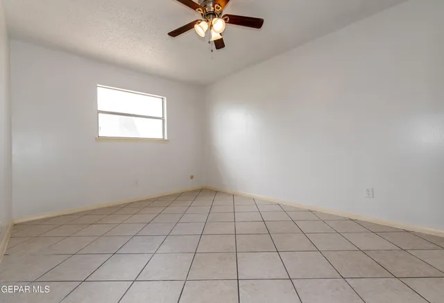 an empty room with windows and ceiling fan