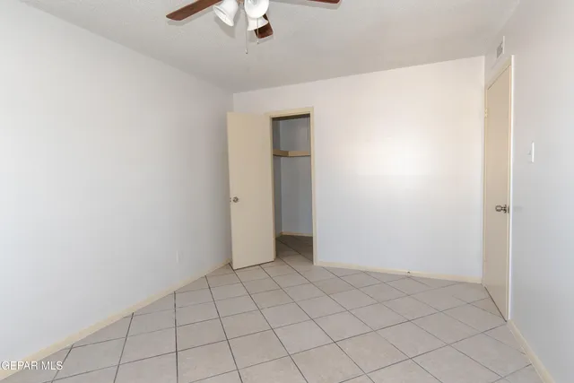 an empty room with chandelier fan
