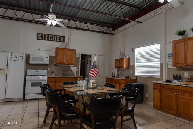 a room with kitchen island stainless steel appliances wooden floor and cabinets