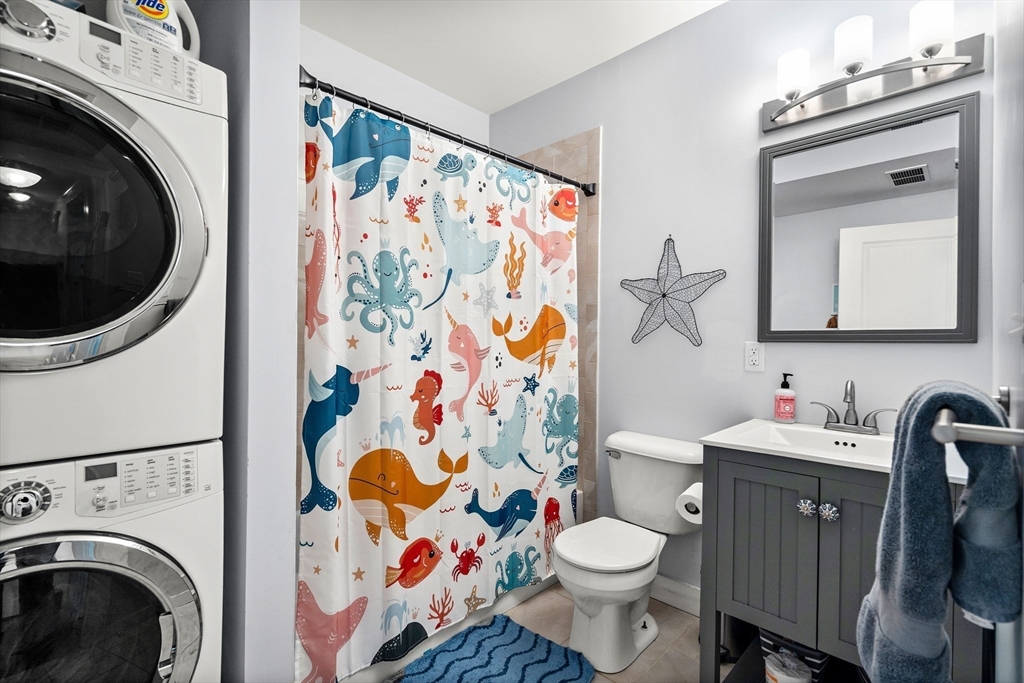 51 New Ocean Street, Unit 2 Swampscott, MA 01907 - Photo 17 of 20 a bathroom with a toilet sink vanity and mirror