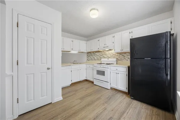 a kitchen with white cabinets and white appliances