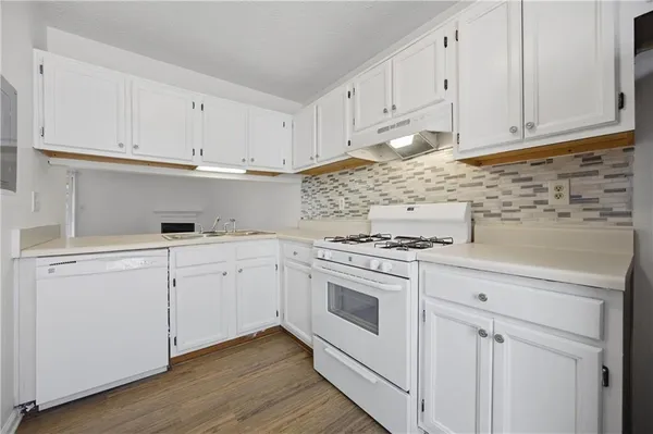 a kitchen with white cabinets and white appliances