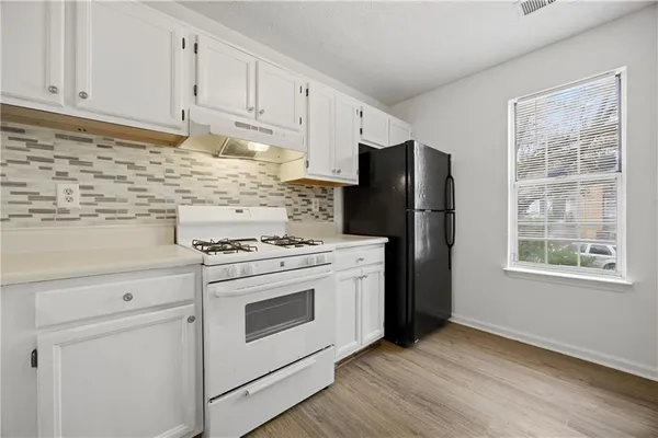 a kitchen with wooden cabinets and a stove top oven
