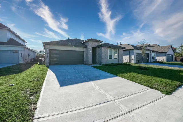 a view of a white house with a yard and potted plants