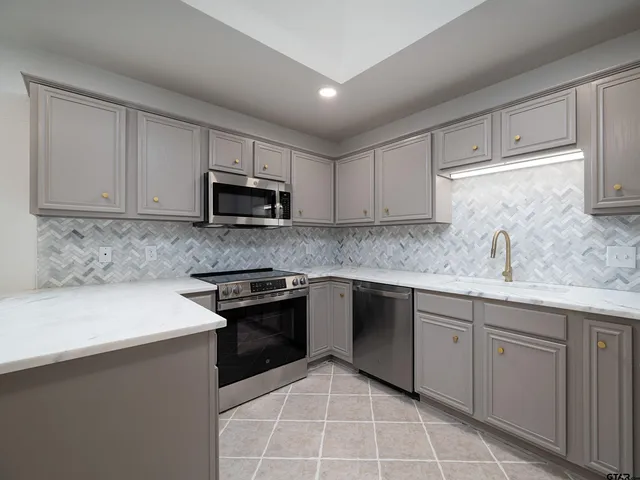 a kitchen with cabinets appliances and a sink
