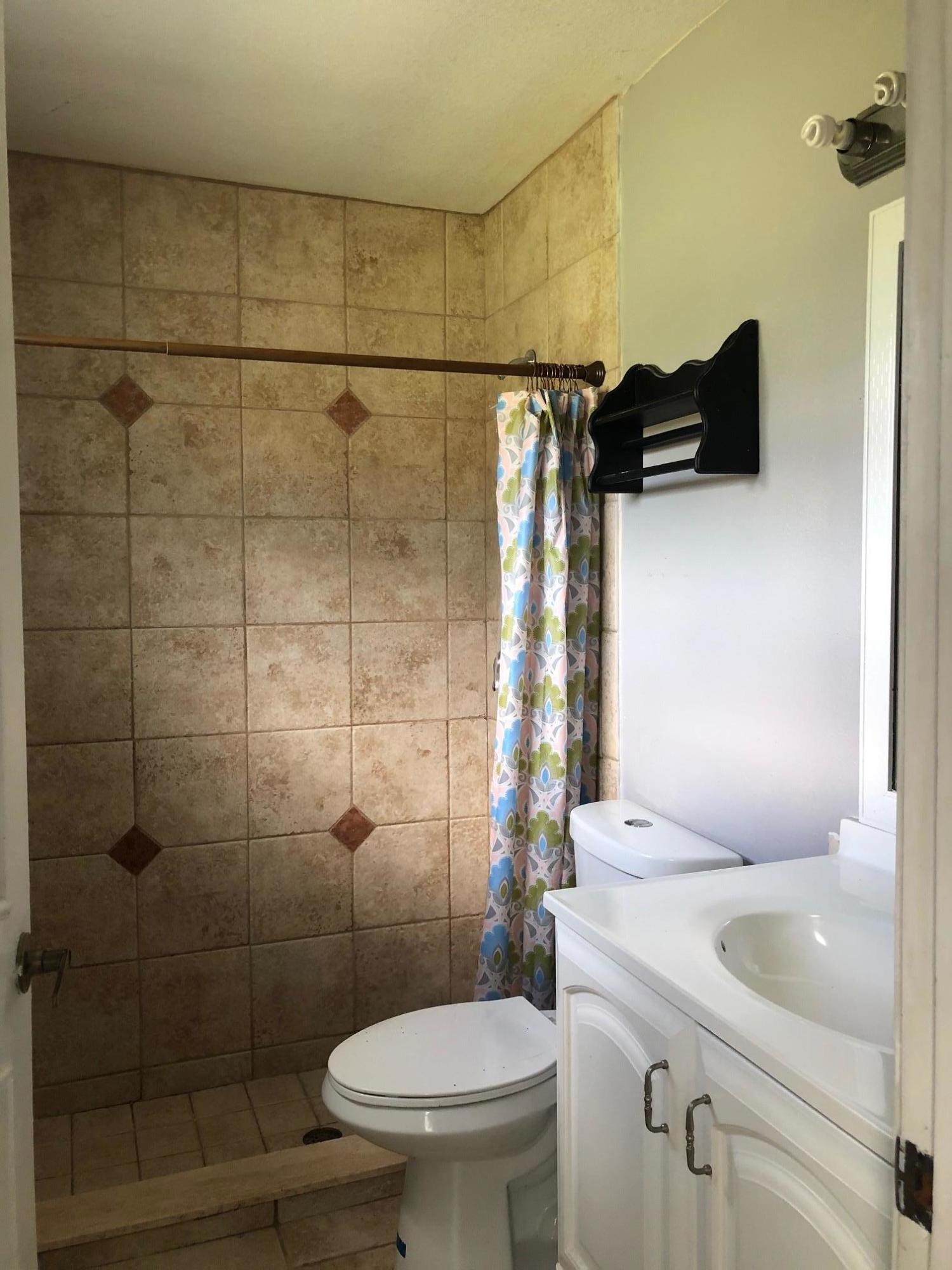 362 Southwest Kentwood Road Port St. Lucie, FL 34953 - Photo 3 of 4 a bathroom with a sink toilet and shower