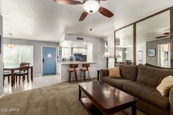a living room with furniture kitchen view and a dining table