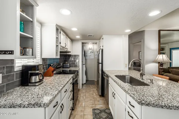 a kitchen with stainless steel appliances granite countertop a sink stove and refrigerator