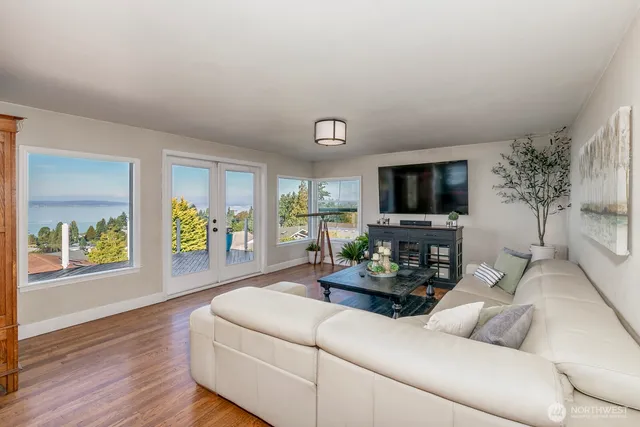 a living room with furniture flat screen tv and a large window