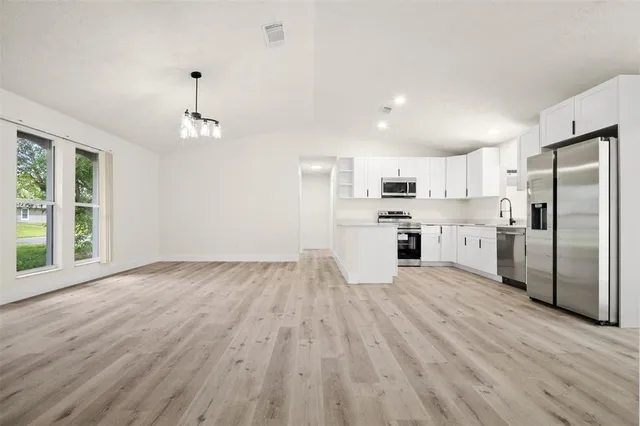 an aerial view of a house with a garden and lake view