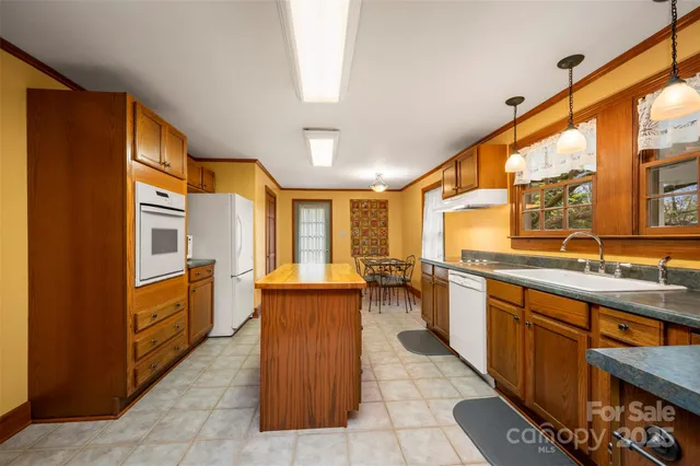 a kitchen with stainless steel appliances granite countertop a sink stove and cabinets
