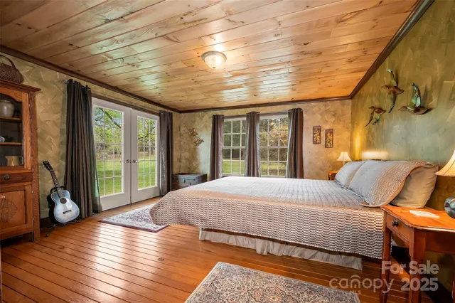 a spacious bedroom with a bed and wooden floor