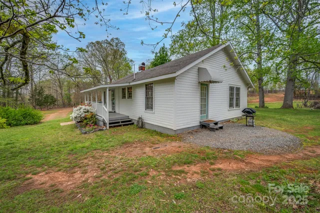a view of a yard in front of a house with large trees