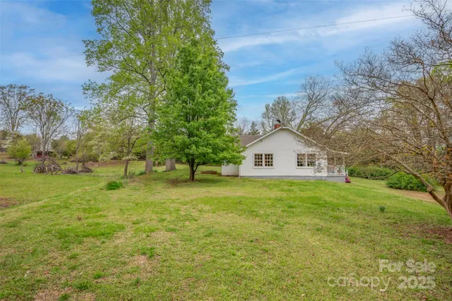 a view of a house with a yard and tree