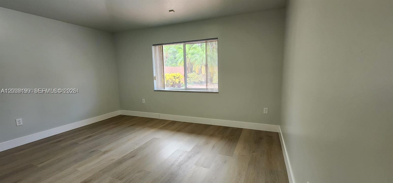 14817 Southwest 180th Street Miami, FL 33187 - Photo 8 of 15 an empty room with wooden floor and windows