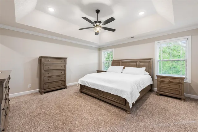 a spacious bedroom with a bed and ceiling fan