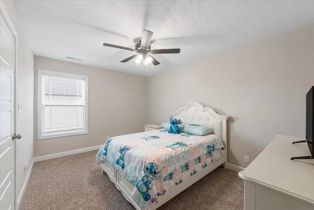 a bedroom with a bed chandelier and a window