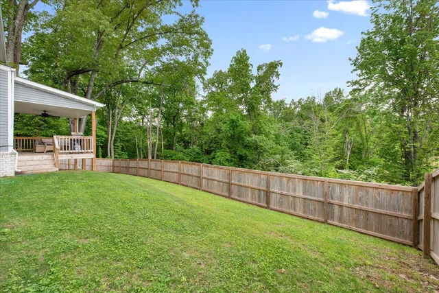 a view of a backyard with a garden and deck