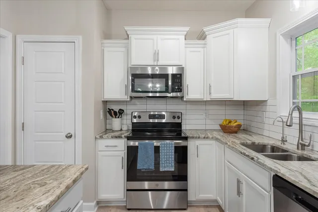 a kitchen with granite countertop a stove sink and microwave
