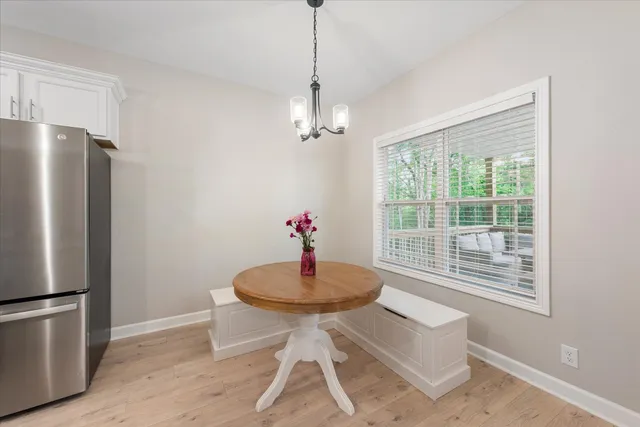 a dining room with furniture a chandelier and wooden floor