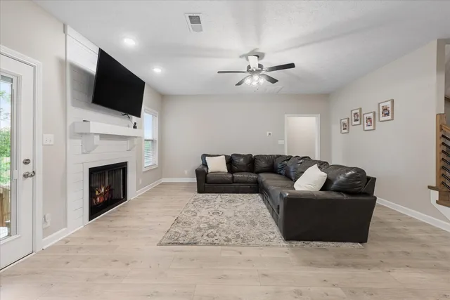 a living room with furniture a flat screen tv and a fireplace
