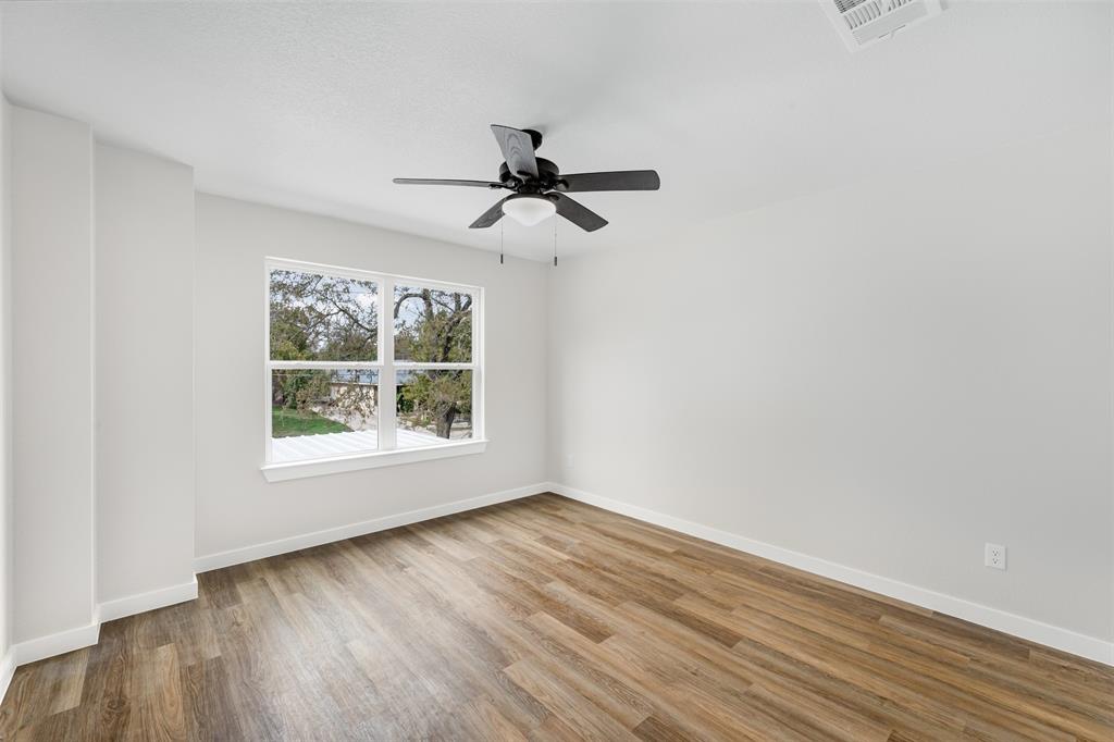 1536 Alexander Avenue, Unit A & B Waco, TX 76708 - Photo 21 of 31 This room features light-toned walls, wood-style flooring, a window offering natural light, and a ceiling fan