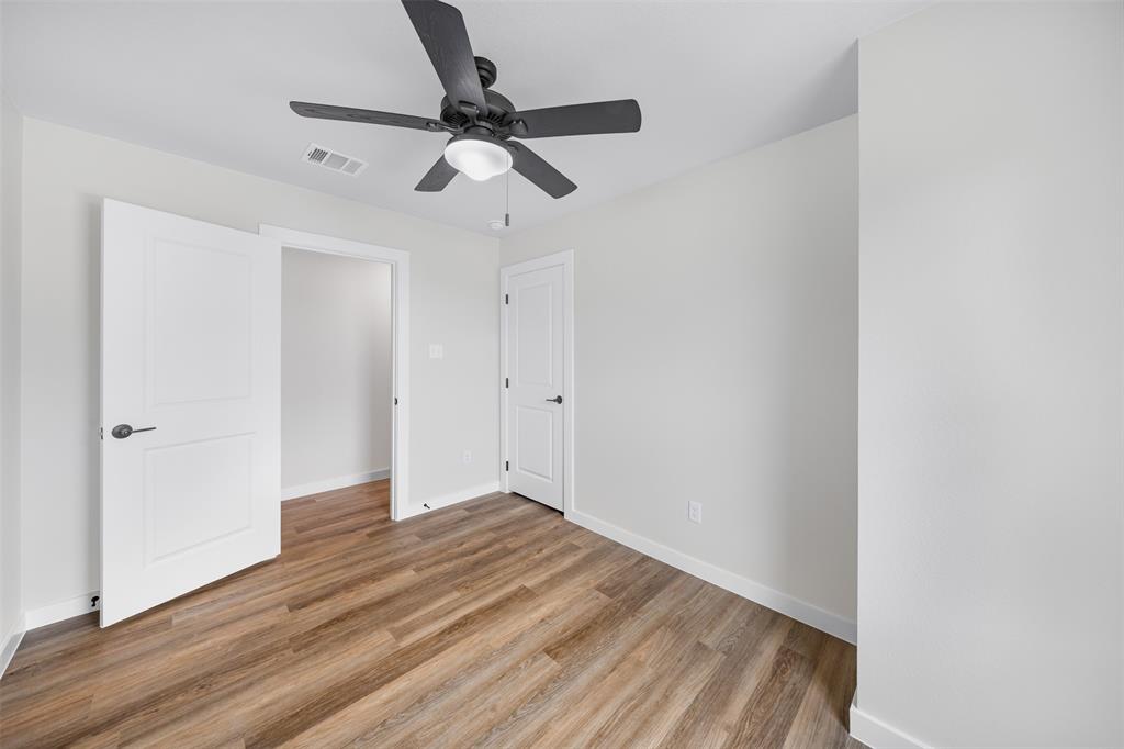 1536 Alexander Avenue, Unit A & B Waco, TX 76708 - Photo 25 of 31 This room features wood-look flooring, light-colored walls, and a ceiling fan with an integrated light fixture