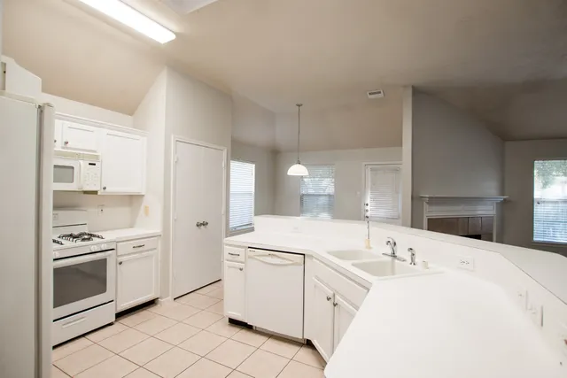 a kitchen with white cabinets and white appliances