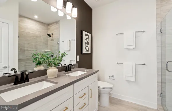 a bathroom with a granite countertop sink a toilet and mirror
