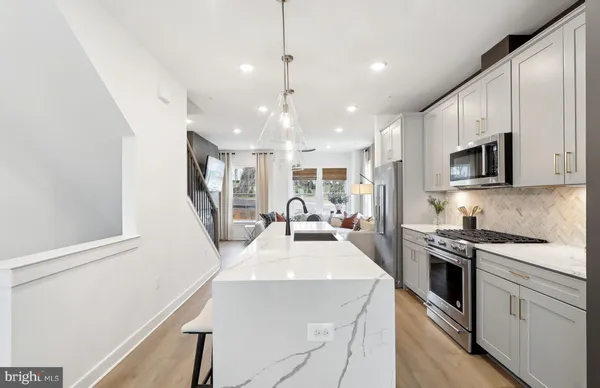 a kitchen with kitchen island a stove a sink a microwave and refrigerator