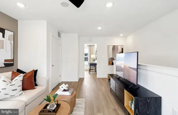 a living room with furniture and a wooden floor