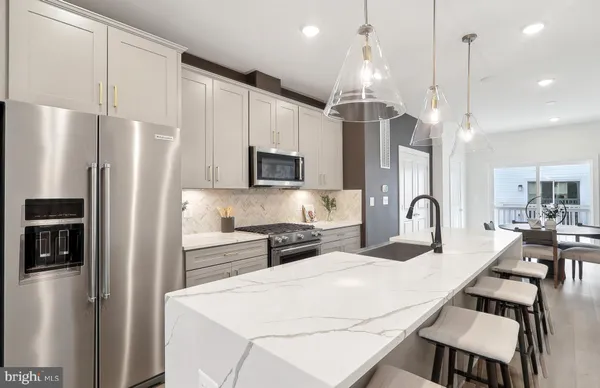 a kitchen with stainless steel appliances a refrigerator sink and microwave