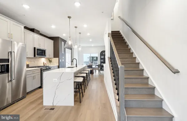 a dinning room and kitchen with furniture wooden floor and windows