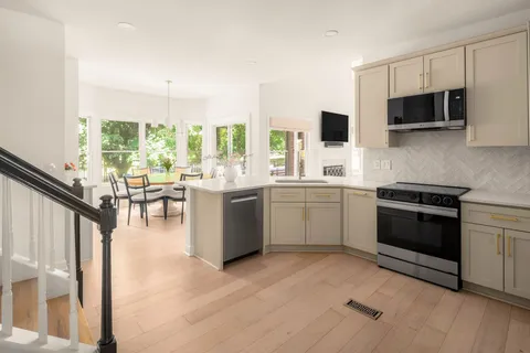 a kitchen with stainless steel appliances a stove a sink and a microwave