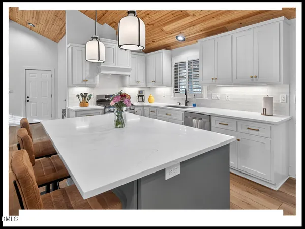 a kitchen with cabinets and wooden floor