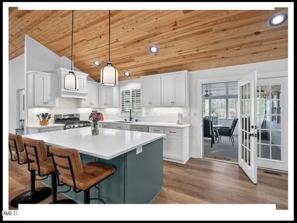 a kitchen with stainless steel appliances granite countertop a sink table and chairs