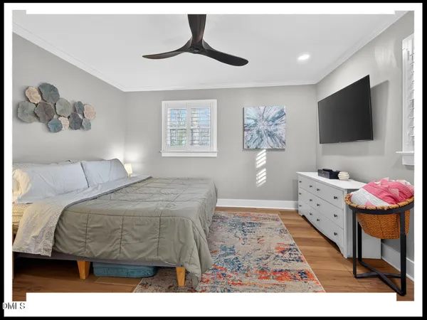 a spacious bedroom with a bed and a flat screen tv