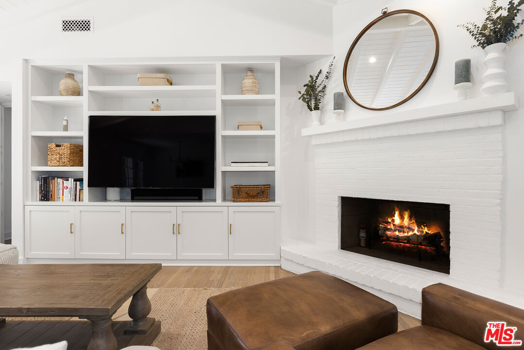 3404 Merrimac Road Los Angeles, CA 90049 - Photo 7 of 29 a living room with furniture a fireplace and a flat screen tv