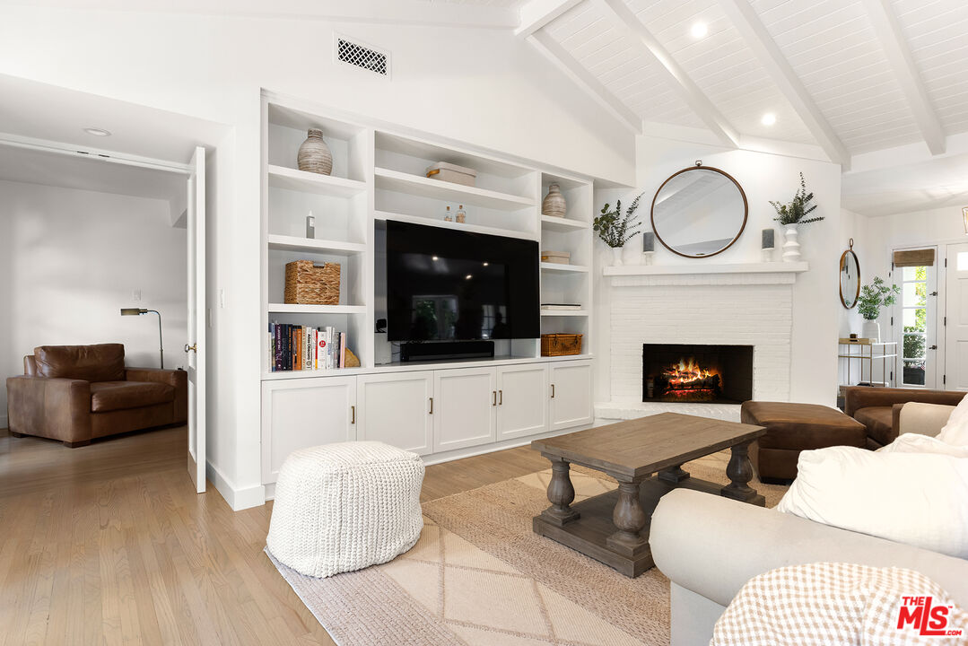 3404 Merrimac Road Los Angeles, CA 90049 - Photo 8 of 29 a living room with furniture a fireplace and a flat screen tv