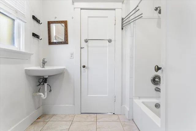 a bathroom with a sink a mirror a bathtub and shower