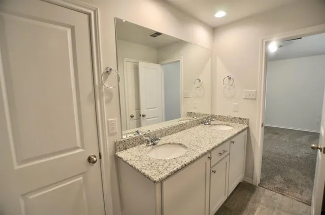 a bathroom with a granite countertop sink and a mirror